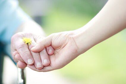 Young and senior women holding hands